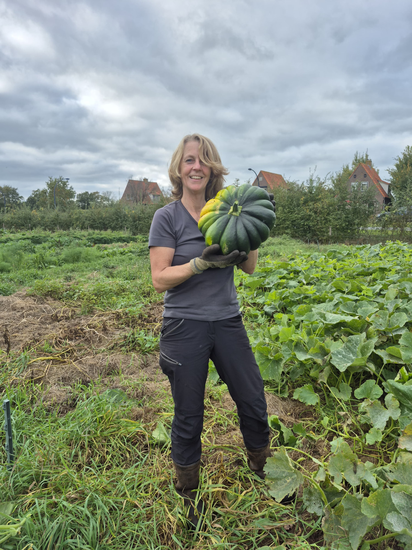 Laura met een pompoen in de zelfoogsttuin