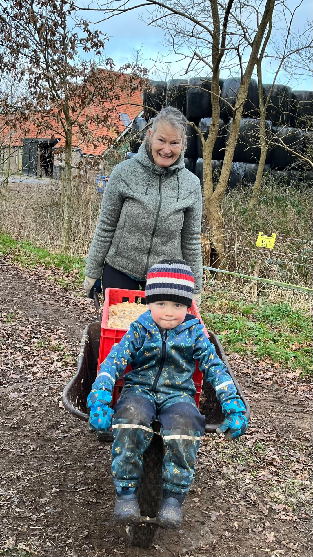 Gerda met Rowan in de kruiwagen op het landgoed