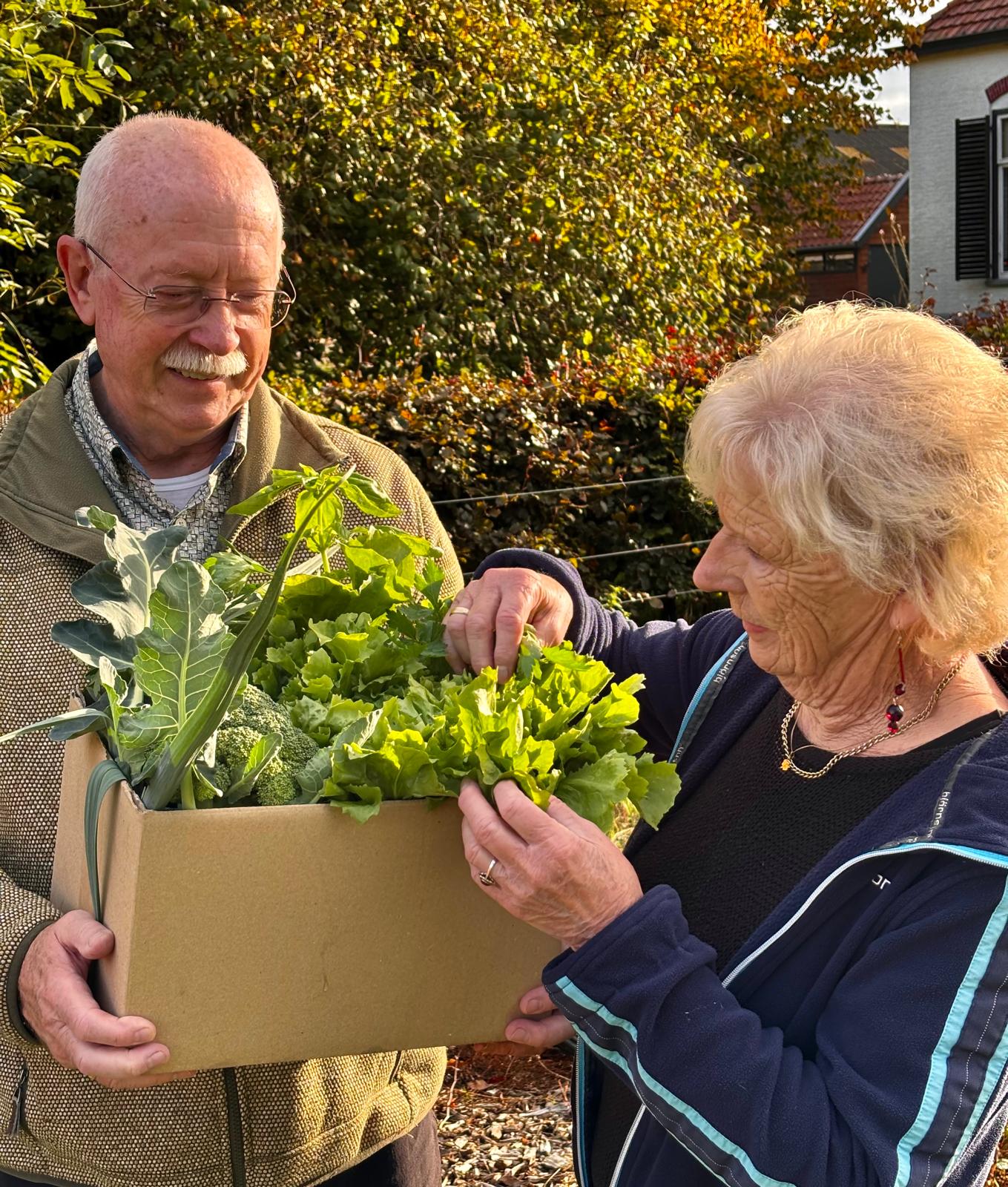 Ans en Wim met een kist verse groenten uit de tuin